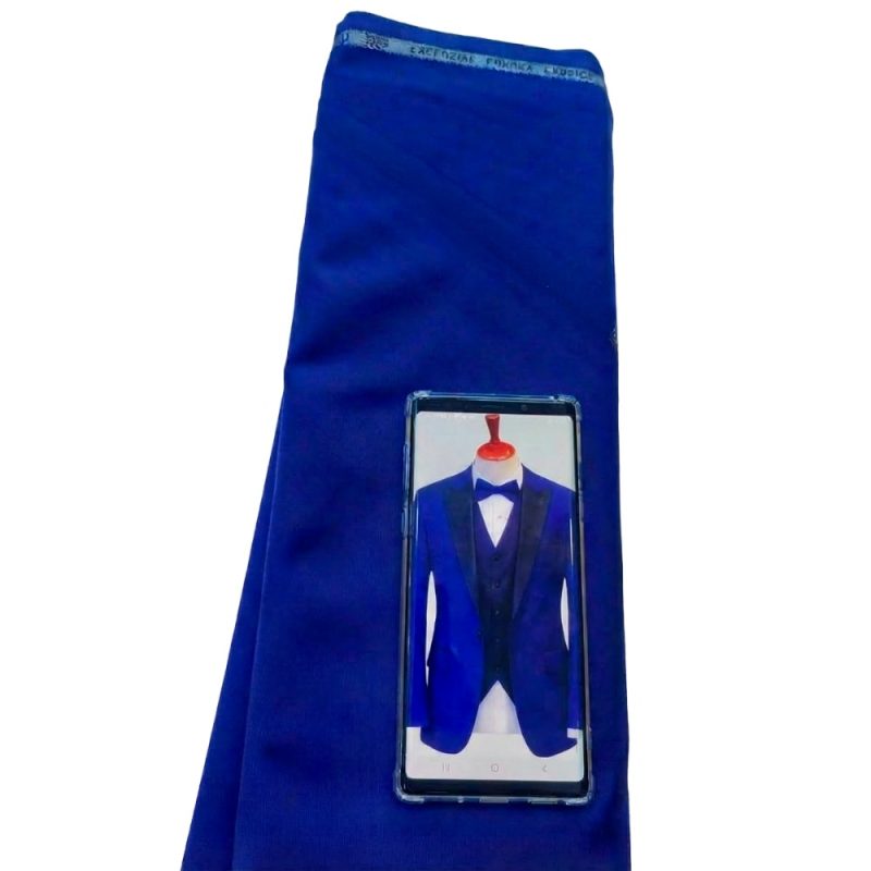 Royal blue tuxedo fabric displayed with custom tuxedo design reference on a smartphone, showing premium fabric selection for a tailored blue tuxedo suit.