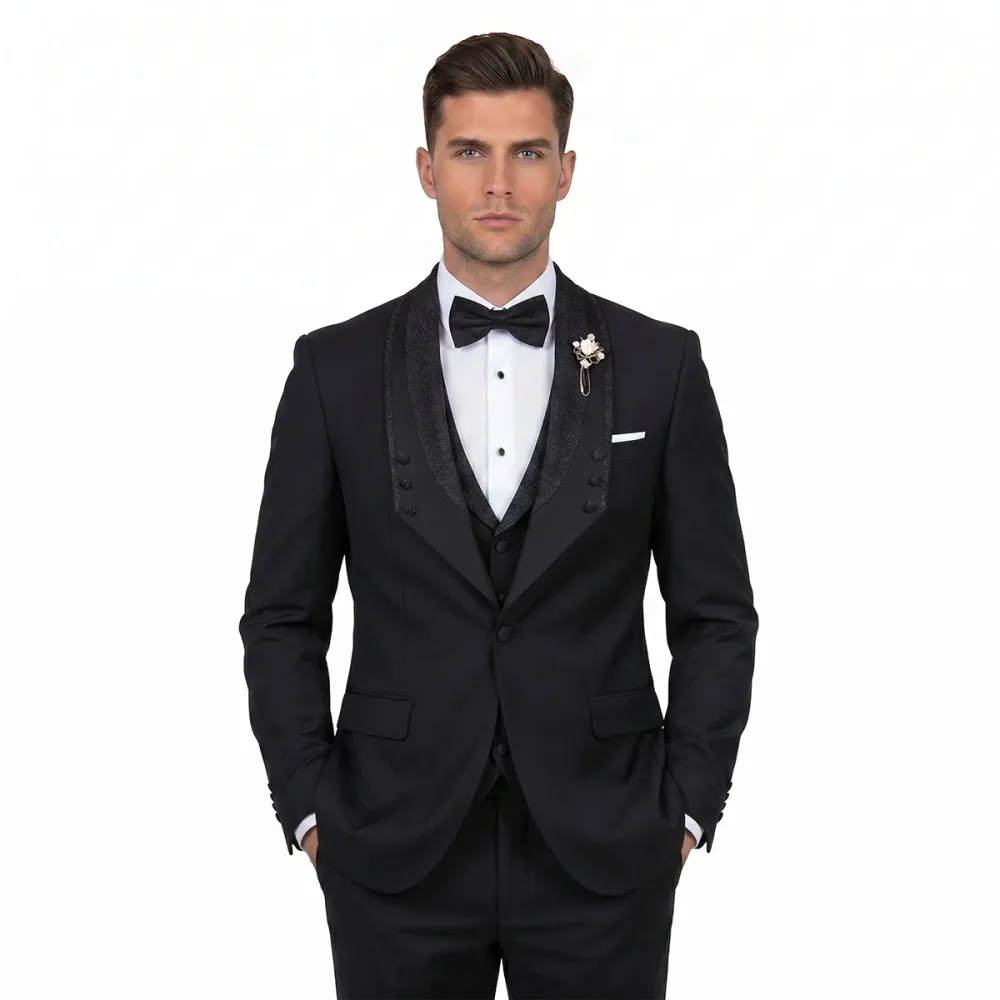 Men’s custom black tuxedo with glitter lapel, matching vest, white dress shirt, black bow tie, pocket square, and lapel pin by Andre Emilio