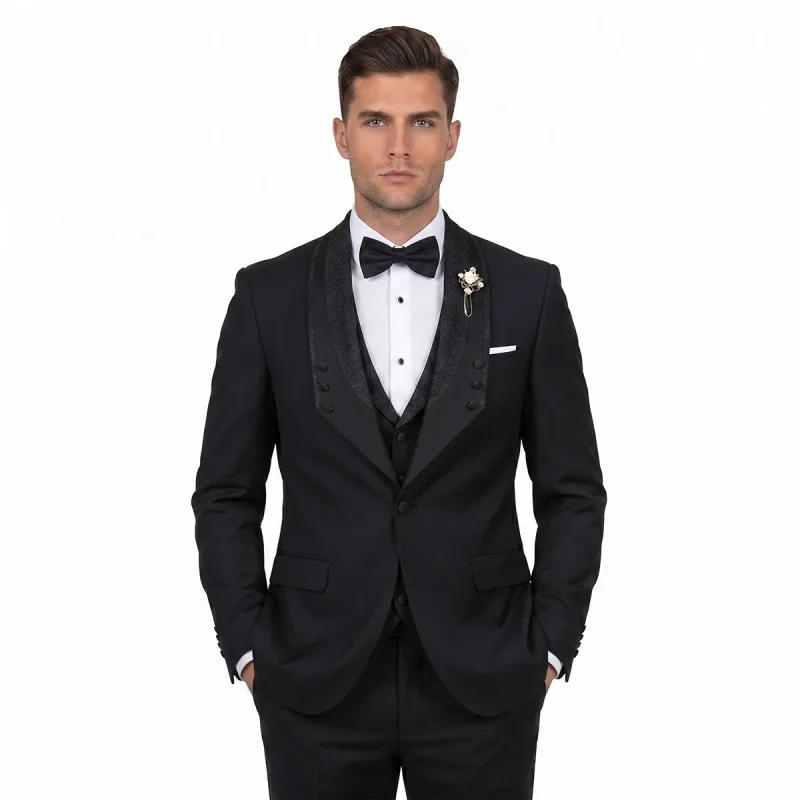 Men’s custom black tuxedo with glitter lapel, matching vest, white dress shirt, black bow tie, pocket square, and lapel pin by Andre Emilio