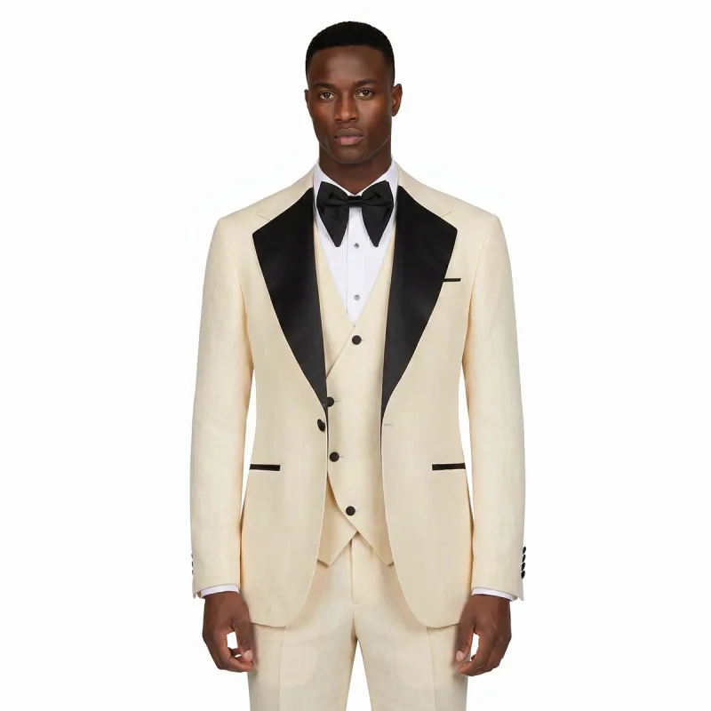 Men’s cream tuxedo with black lapel, matching vest, white dress shirt, and black bow tie by Andre Emilio